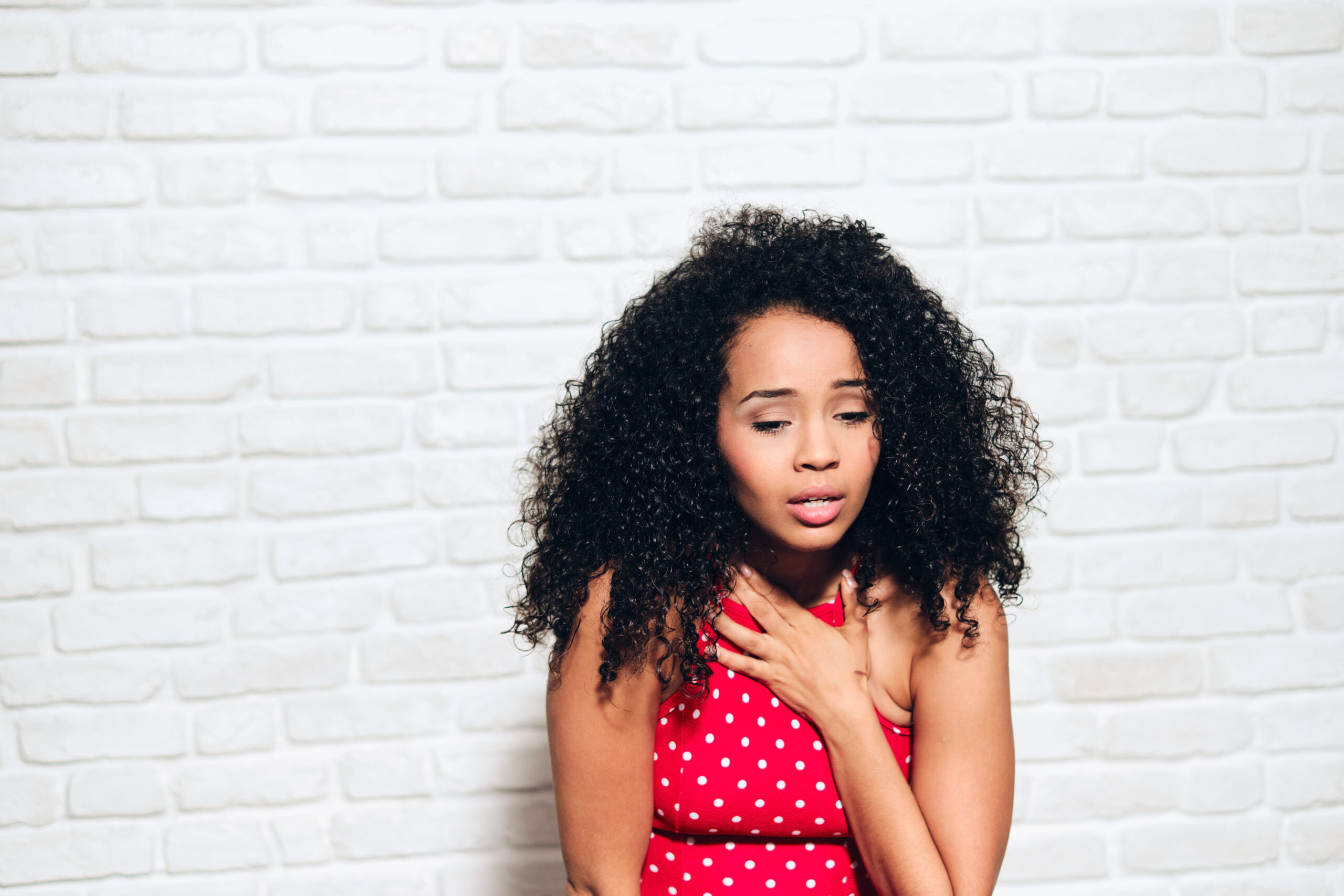 Portrait of nervous african american woman with panic attack. Black girl showing anxiety, sadness and frustration. Sad hispanic person against white wall